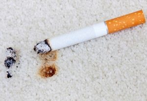 Zigarettenfleck auf Teppich